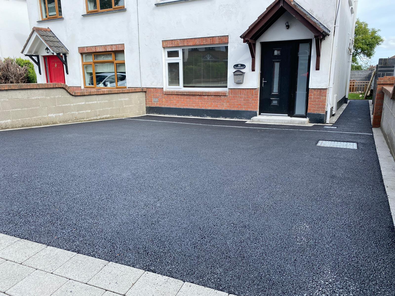 Finished black tarmac driveway outside a house